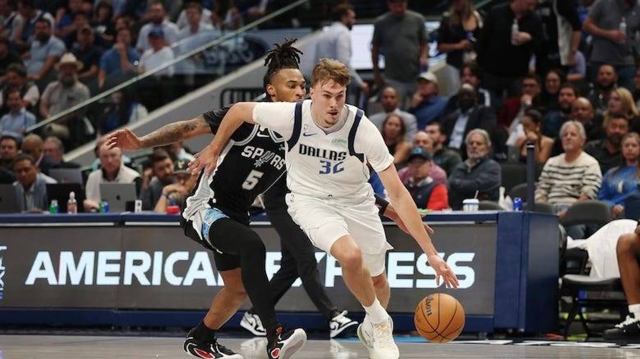 Cooper Flagg #32 of the Dallas Mavericks drives around Stephon Castle #5 of the San Antonio Spurs during a game at American Airlines Center on October 22, 2025 in Dallas, Texas