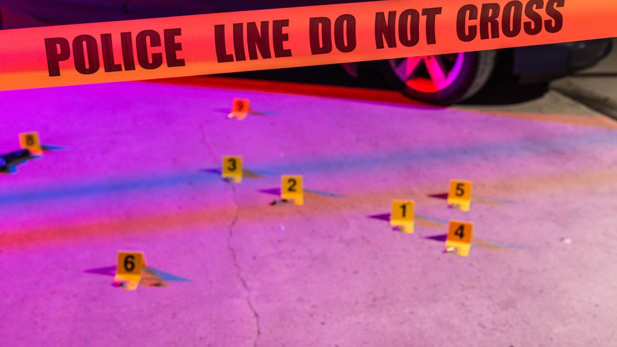 Cordon tape, marking a police line, is stretched in front of a crime scene
