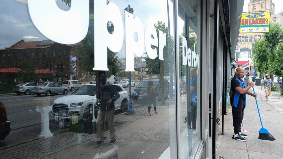 Corey Blackwell cleans up outside of Generations Barber Academy.