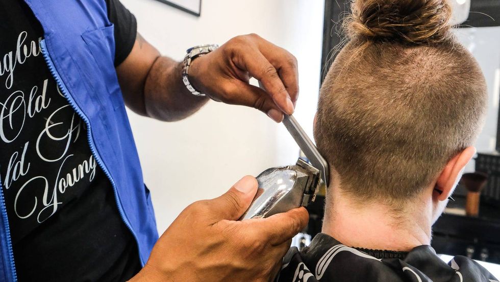 Corey Blackwell gives Genevieve Blankley a trim at Generations Barber Academy.