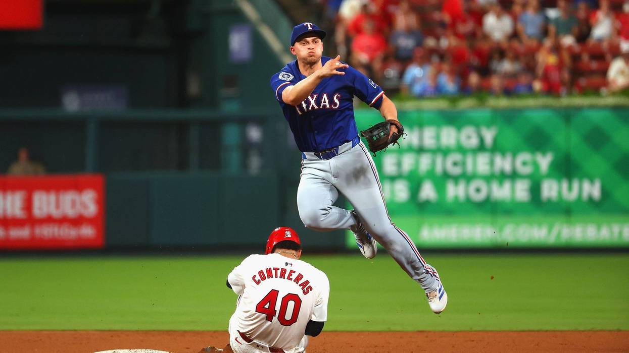 Corey Seager #5 of the Texas Rangers turns s double play over Willson Contreras #40 of the St. Louis Cardinals in the seventh inning at Busch Stadium on July 30, 2024 in St Louis, Missouri.