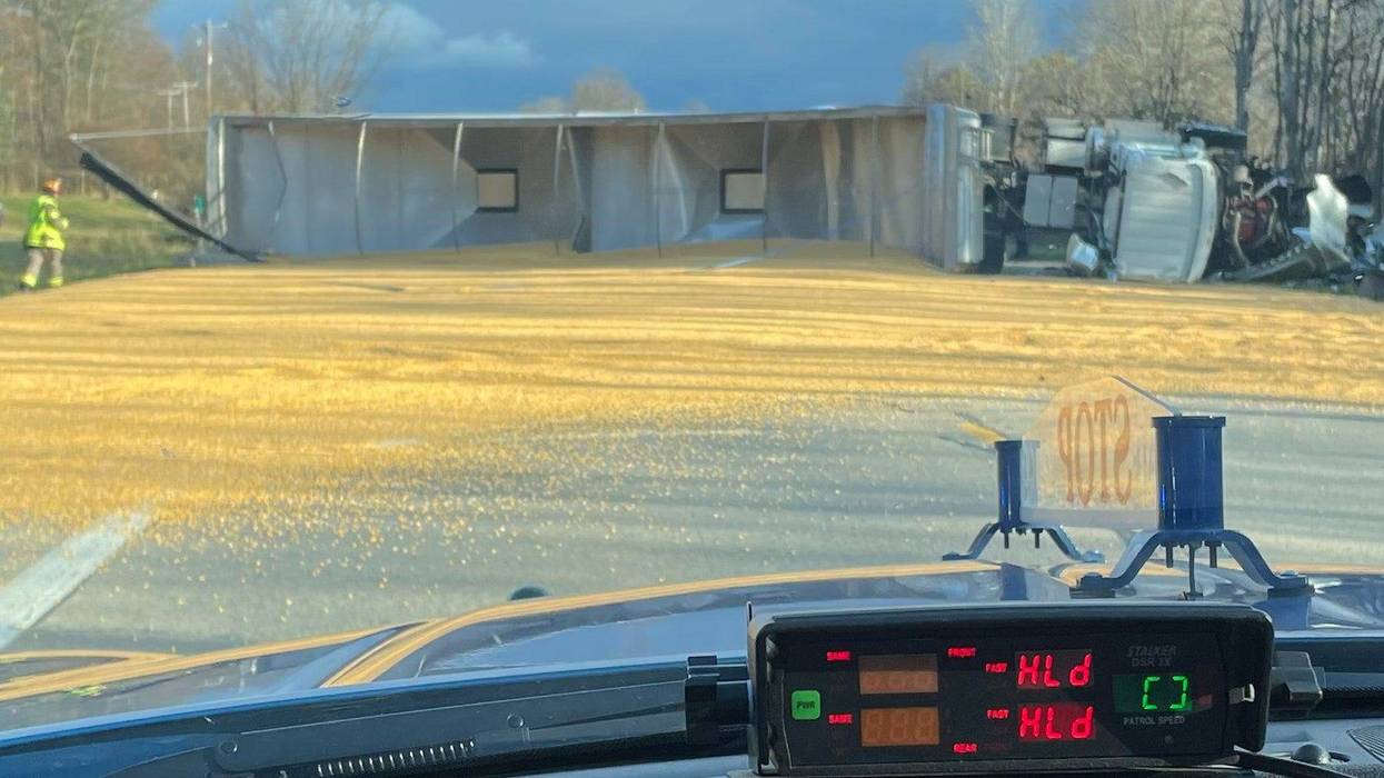 Corn spilled on road, overturned semi