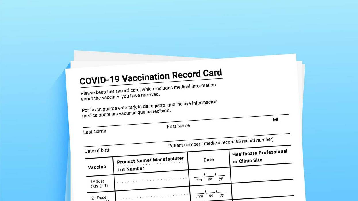 Coronavirus vaccination record card on a blue background