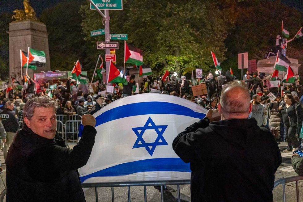 Counter-demonstrators hold an Israeli flag across the street from a pro-Palestinian rally in Midtown Manhattan on Saturday