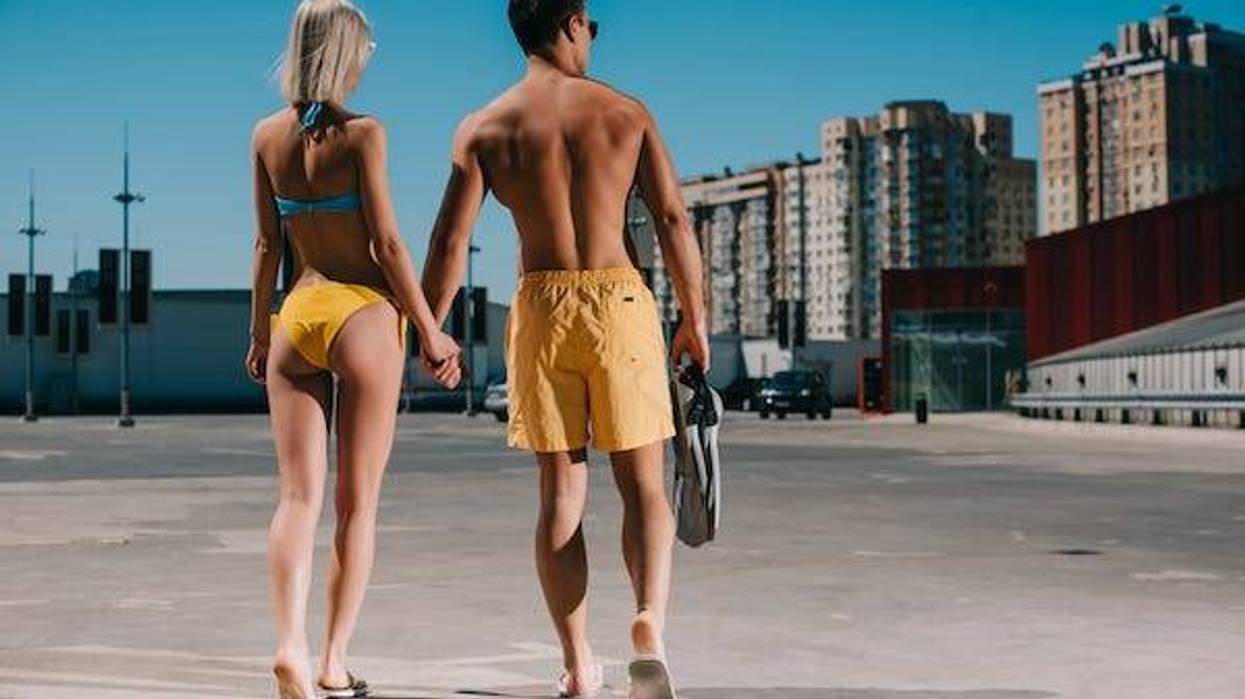 Couple walking around city in their swimsuits