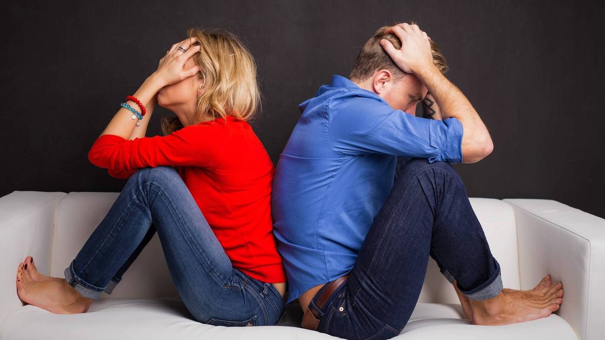 Couple with their backs turned to each other sitting on couch