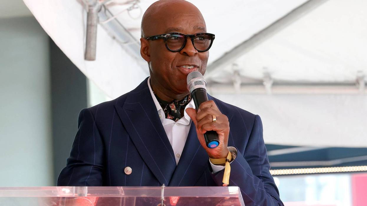 Courtney B. Vance stands at podium with microphone in hand