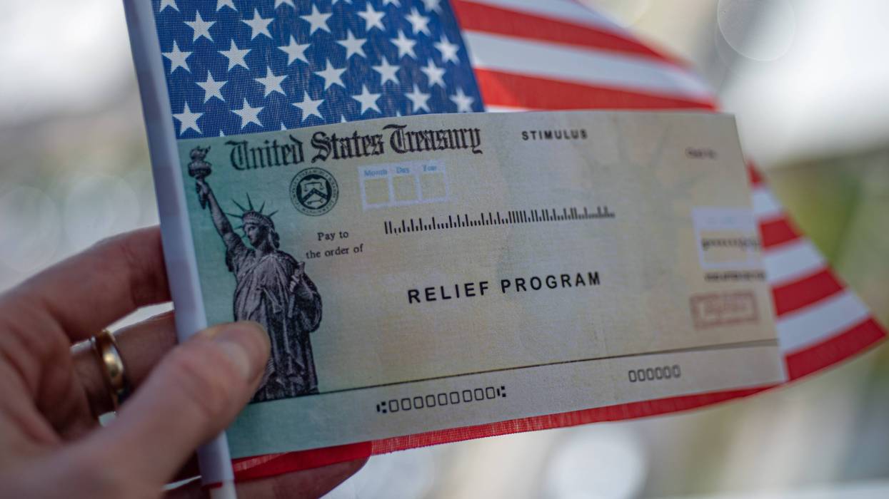 COVID-19 economic stimulus check on blurred USA flag background