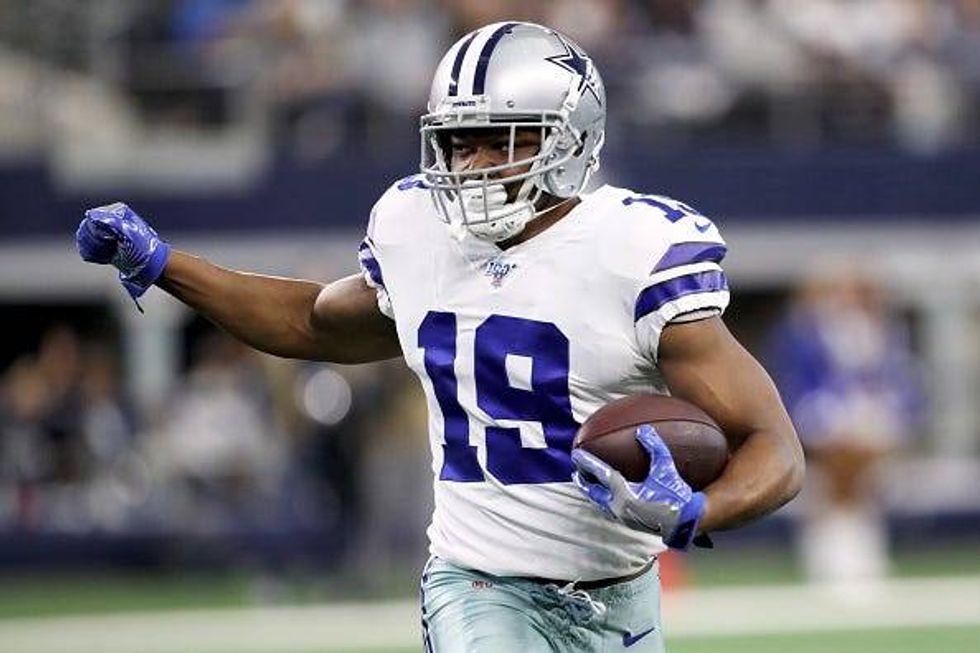Cowboys WR Amari Cooper looks to make a move after a reception.