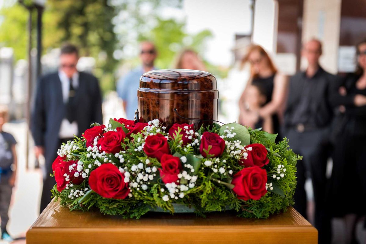 Cremated remains in urn with flowers, family, stock photo.
