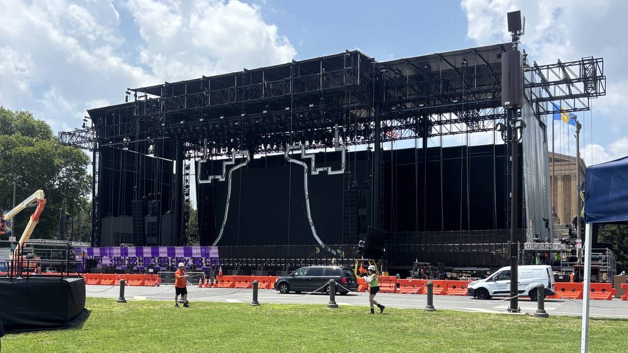 Crews work to complete the stage for the city's Fourth of July concert on the Ben Franklin Parkway.