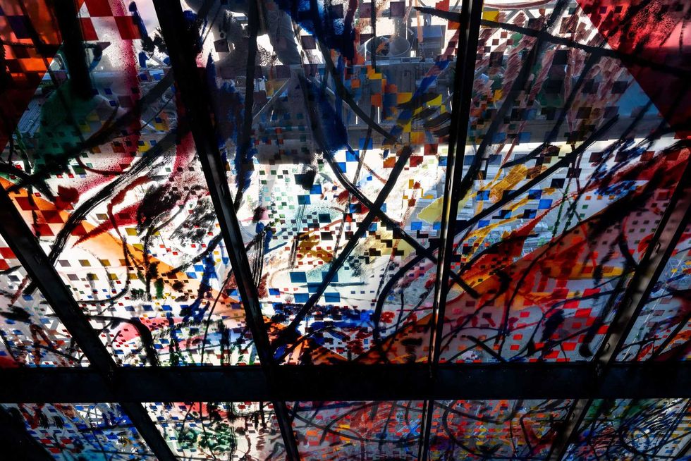 Crews work to install one of 35 stained glass panels for "Uprising of the Sun."