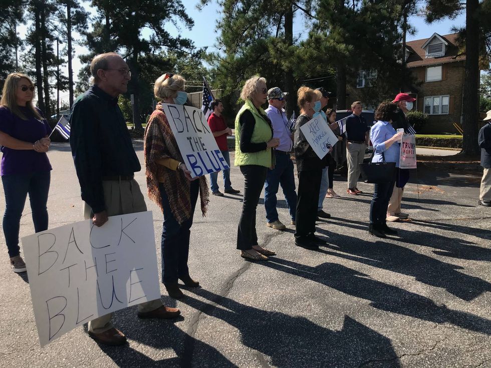 Crowd holds signs during AG Wilson