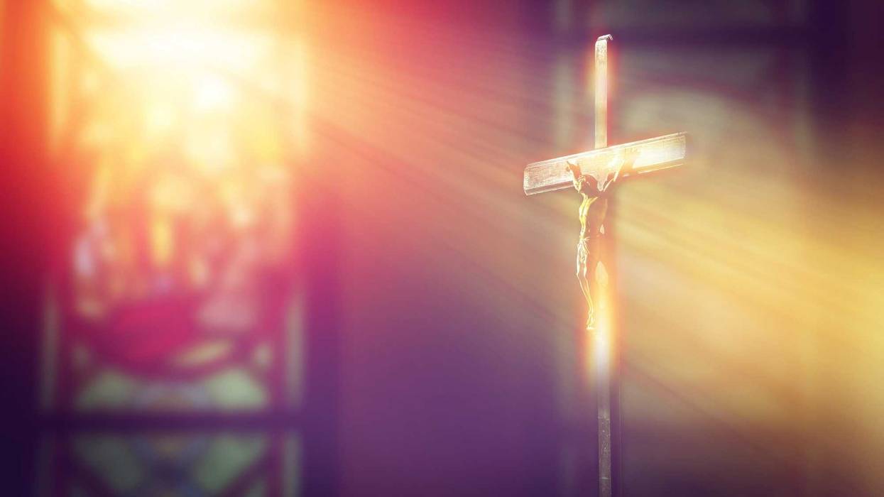 Crucifix in church with ray of light from stained glass