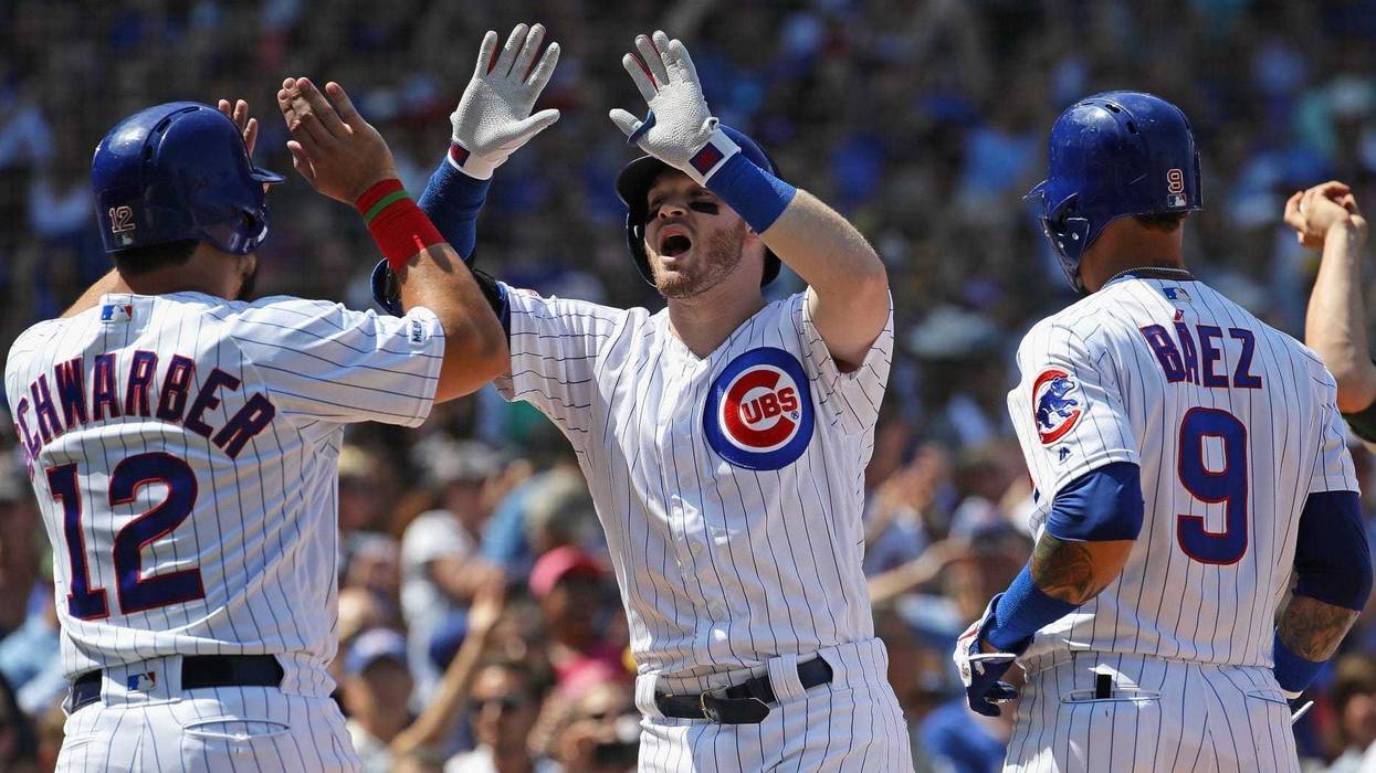 Cubs infielder/outfielder Ian Happ is greeted by teammates after hitting a grand slam against the Athletics.