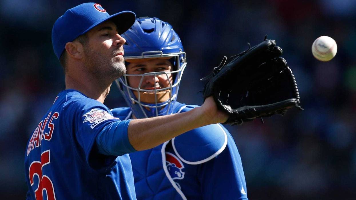 Cubs left-hander Cole Hamels (35) catches a ball as catcher Victor Caratini (7) looks on.