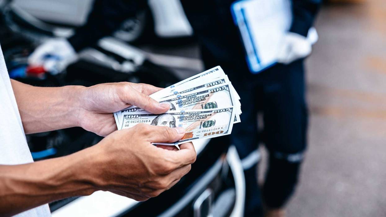 Customer pay with money for repair to the mechanic at garage workshop, Spending and car financial concept.