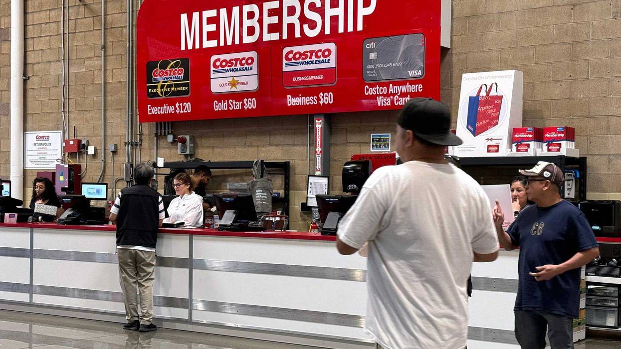 Customers walk by the membership counter at a Costco store. Costco announced plans to raise membership fees for the first time since 2017 with a $5 jump to $65 a year from $60.