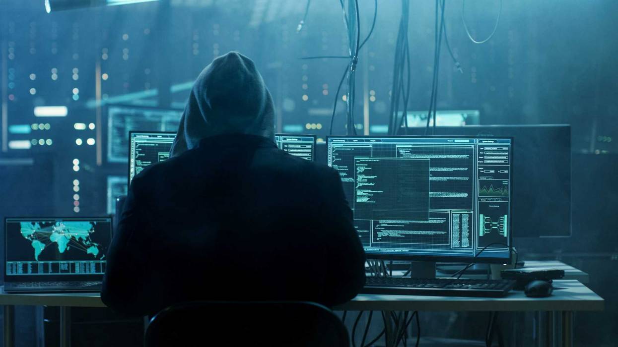 Cyber attacker sitting in front of their computers.