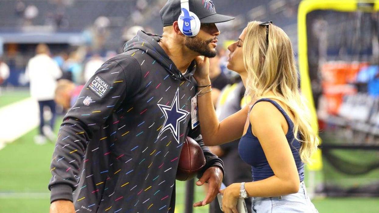 Dak Prescott #4 of the Dallas Cowboys kisses Natalie Buffett on the field before the game against the Carolina Panthers at AT&T Stadium on October 03, 2021 in Arlington, Texas.