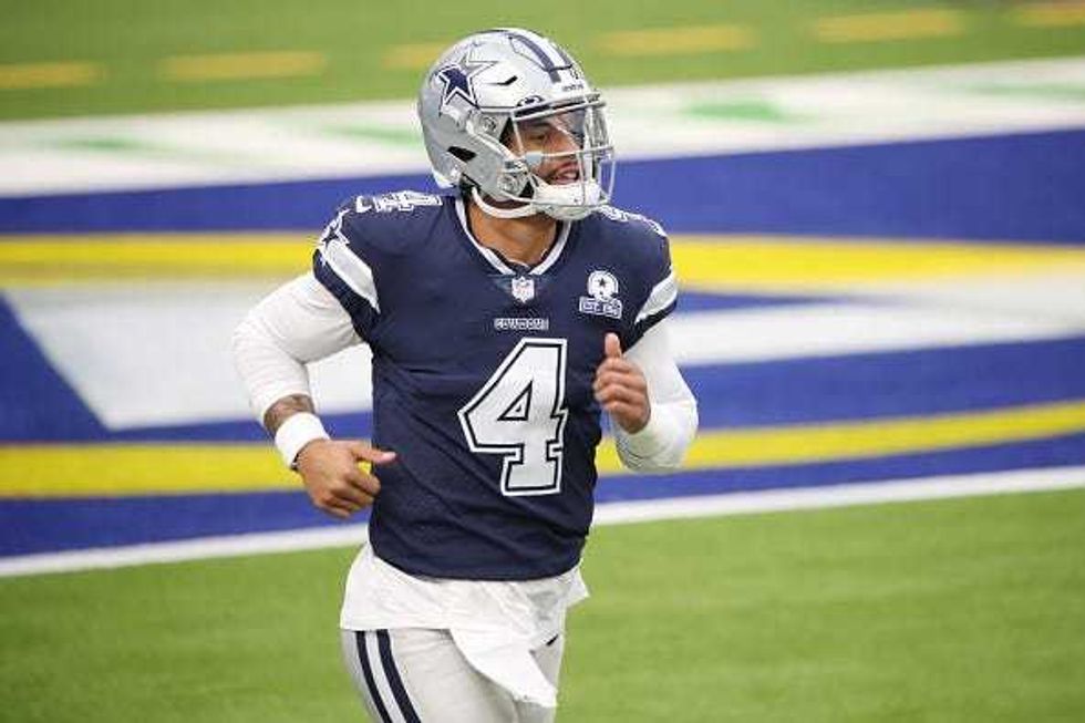 Dak Prescott jogs on the field with the Cowboys.