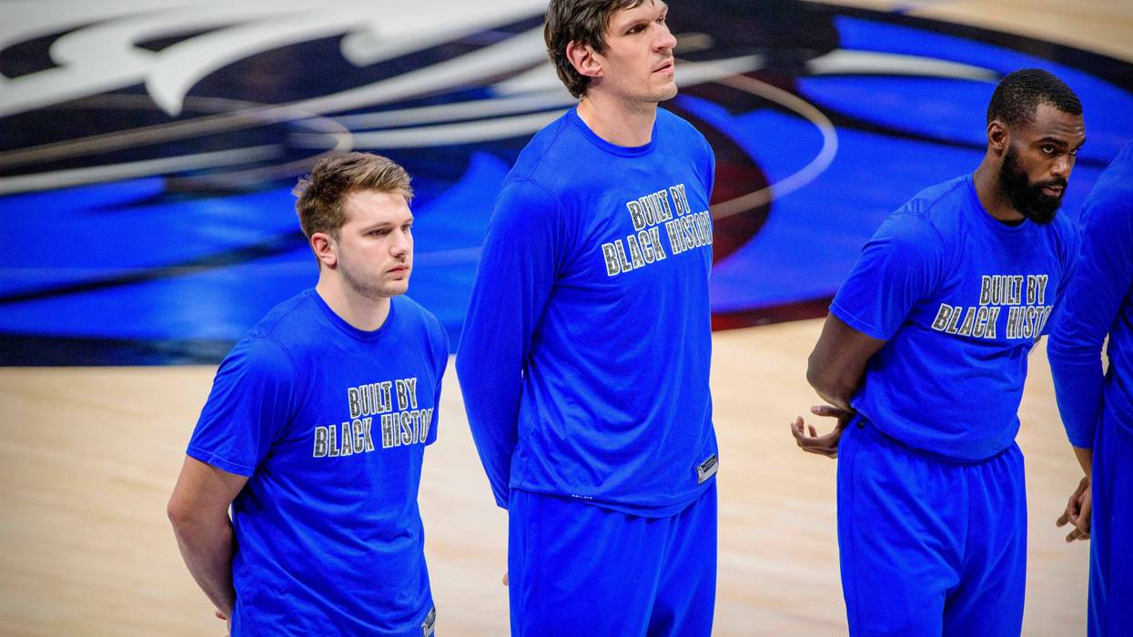 Dallas Mavericks players stand during the national anthem