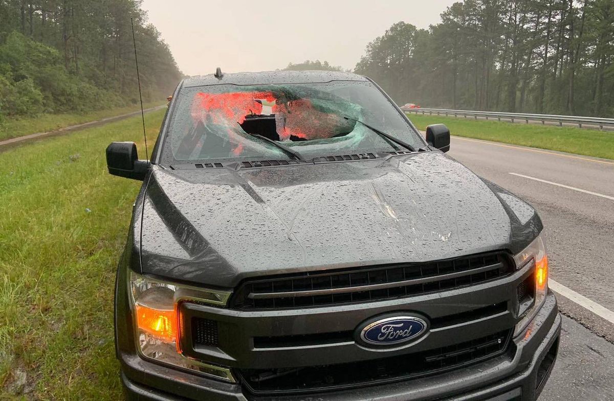 Damage caused to a Ford truck after a lightening bolt send chucks of the pavement through the front and back windshield