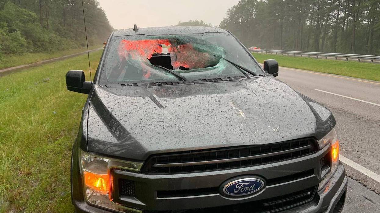 Damage caused to a Ford truck after a lightening bolt send chucks of the pavement through the front and back windshield