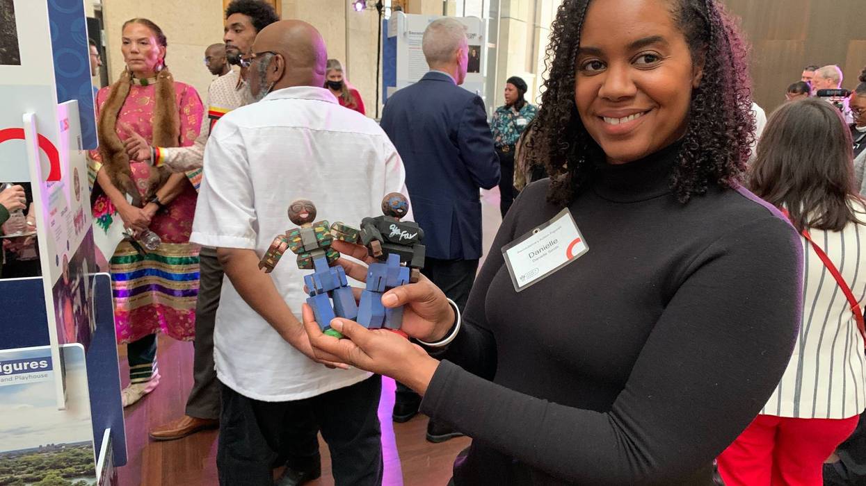 Danielle Smith holds action figures at the Philadelphia250 announcement on Dec. 14 at the Barnes Foundation.