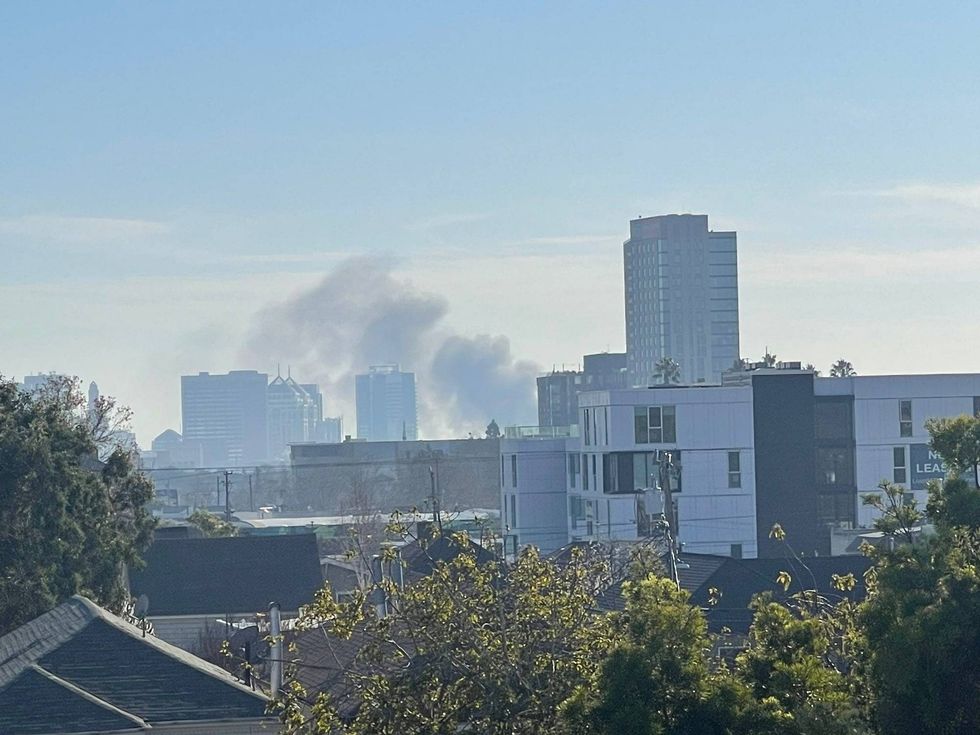 Dark clouds of smoke rose into the Oakland sky Saturday after a boat attached to a parked trailer caught fire.