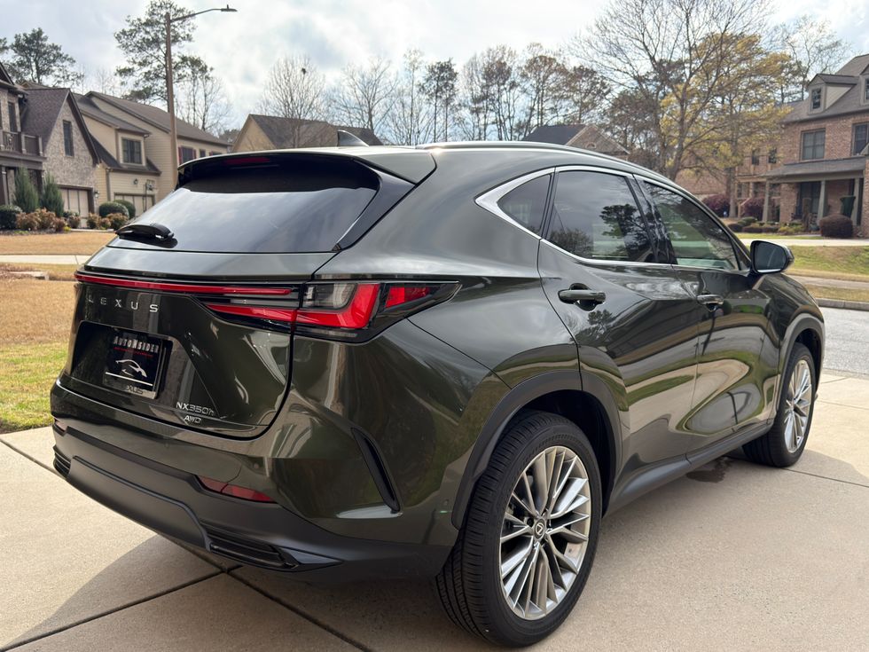 Dark green Lexus NX 350h AWD SUV, rear three-quarter view, on a driveway.