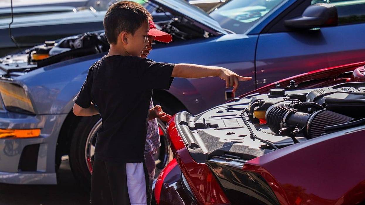 Darren Li, 7, of Troy looks at a Ford Mustang engine with classmate Aadit Rajpathak, 6, of Troy, during the 2019 Woodward Dream Cruise in Ferndale, Mich. on Saturday, Aug. 17, 2019. Dreamcruise 081719 427