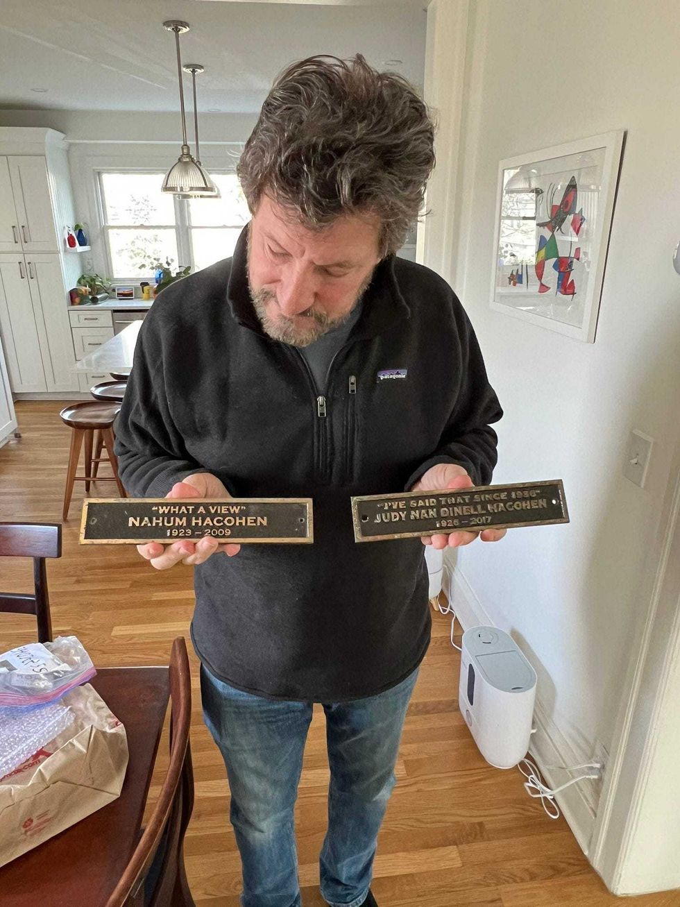 Dean Hacohen holds the plaques of his parents, Nahum and Judy Hacohen