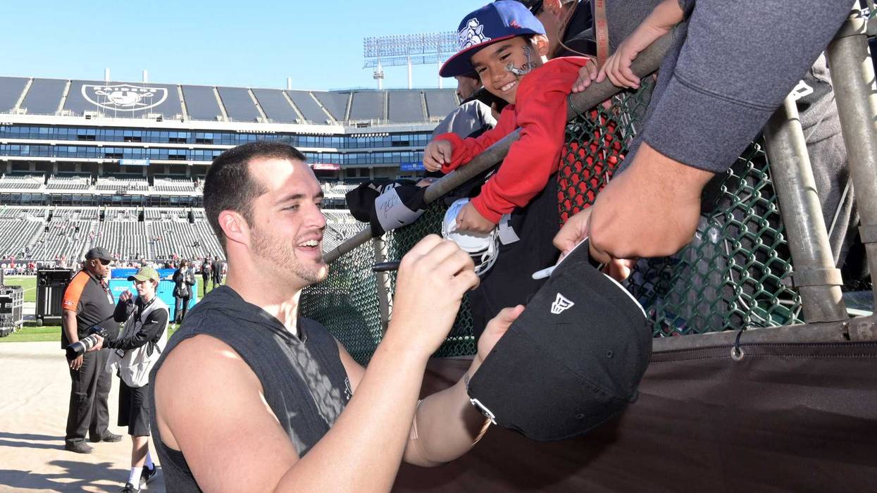 Dec 2, 2018; Oakland, CA, USA; Oakland Raiders quarterback Derek Carr (4) signs autographs before the game against the Kansas City Chiefs at Oakland-Alameda County Coliseum. Mandatory Credit: Kirby Lee-USA TODAY Sports