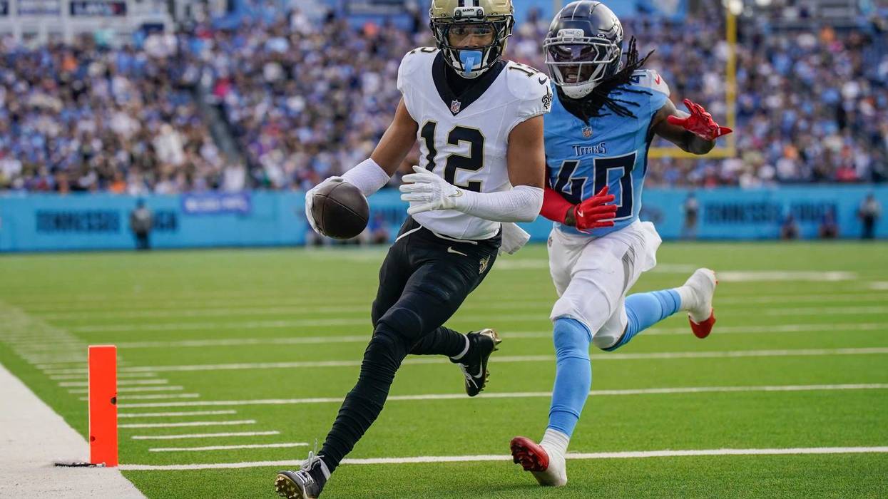 Dec 28, 2025; Nashville, Tennessee, USA; New Orleans Saints wide receiver Chris Olave (12) runs in a touchdown in front of Tennessee Titans cornerback Kemon Hall (40) during the third quarter at Nissan Stadium. Mandatory Credit: Andrew Nelles-USA TODAY Network via Imagn Images