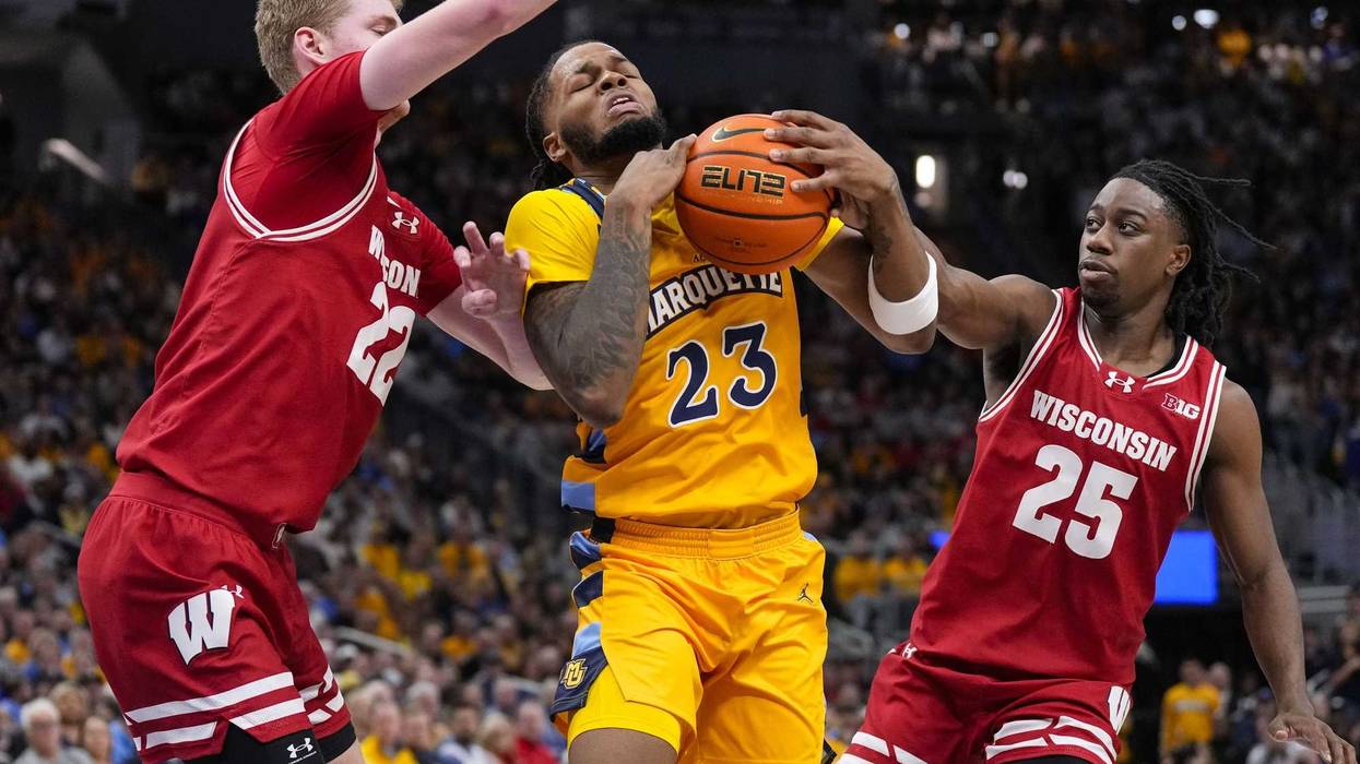 Dec 7, 2024; Milwaukee, Wisconsin, USA; Marquette Golden Eagles forward David Joplin (23) drives for the basket between Wisconsin Badgers forward Steven Crowl (22) and guard John Blackwell (25) during the second half at Fiserv Forum. Mandatory Credit: Jeff Hanisch-Imagn Images