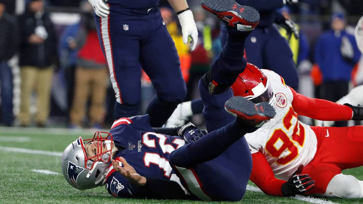 Dec 8, 2019; Foxborough, MA, USA; New England Patriots quarterback Tom Brady (12) tumbles after being sacked by Kansas City Chiefs defensive end Tanoh Kpassagnon (92) during the second quarter at Gillette Stadium. Winslow Townson-USA TODAY Sports