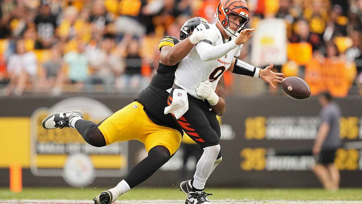 Defensive tackle Derrick Harmon #99 of the Pittsburgh Steelers forces a fumble by quarterback Joe Burrow #9 of the Cincinnati Bengals