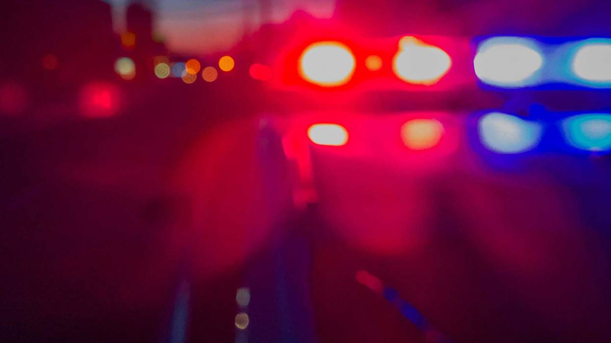 Defocused image of red and blue emergency lights flashing at night.
