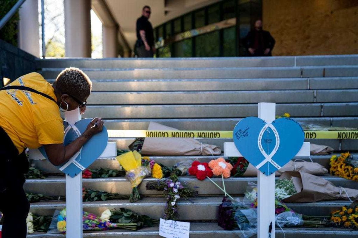 Deindra Bailey writes a message on a cross at the Old National Bank on April 11, 2023 in Louisville, Kentucky.