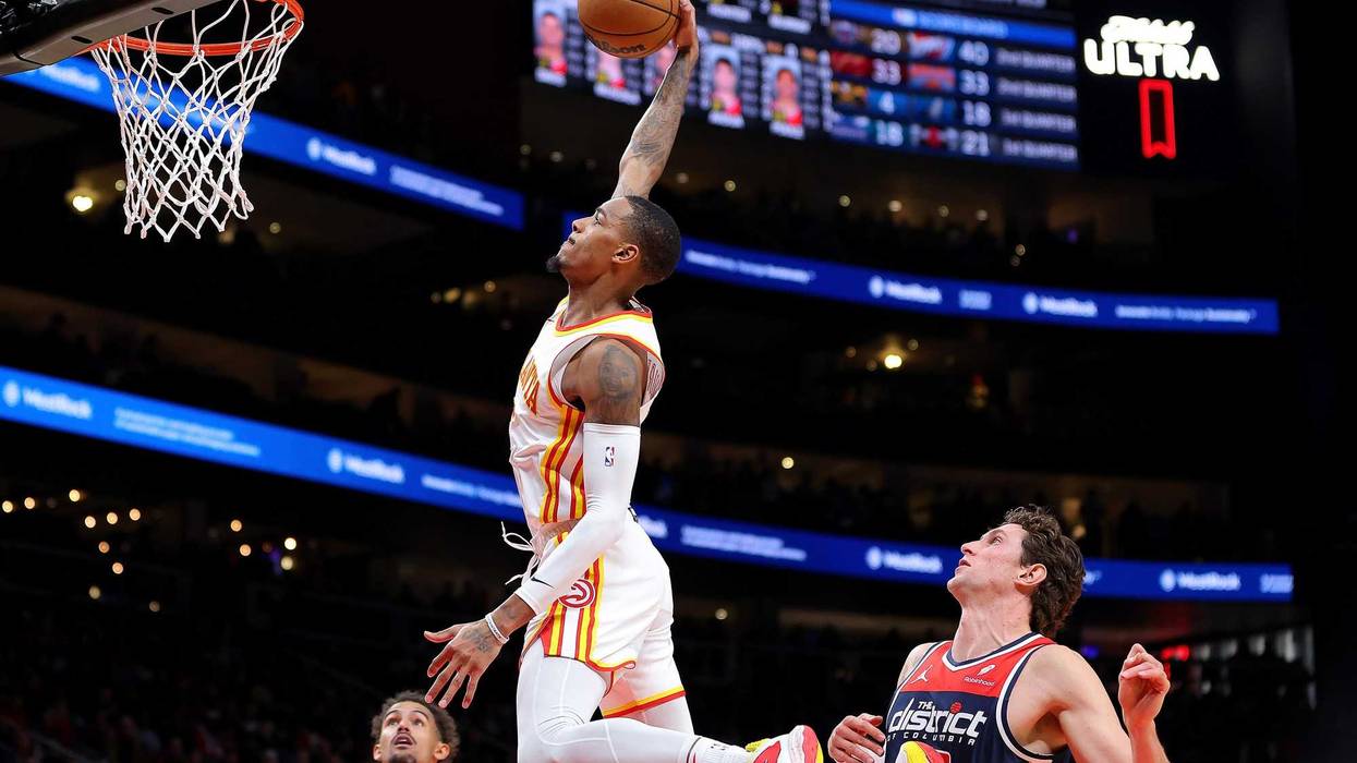 Dejounte Murray #5 of the Atlanta Hawks dunks against Mike Muscala #35 of the Washington Wizards during the second quarter at State Farm Arena