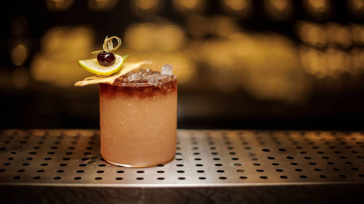 Delicious Mai Tai cocktail with dried pineapple, lime slice and berry