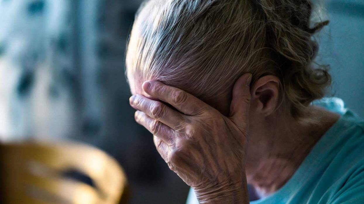 dementia illustration of senior holding her head in hand