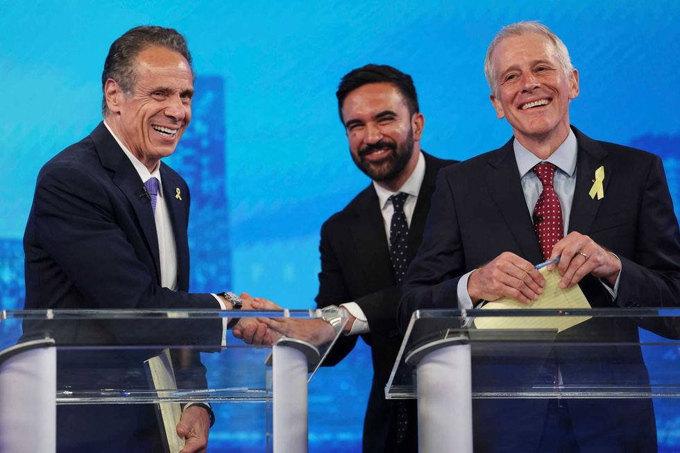 Democratic mayoral candidates Andrew Cuomo, left, shakes hands with Zohran Mamdani, center, as Whitney Tilson reacts after participating in the New York City Democratic Mayoral Primary Debate at NBC Studios on June 4, 2025