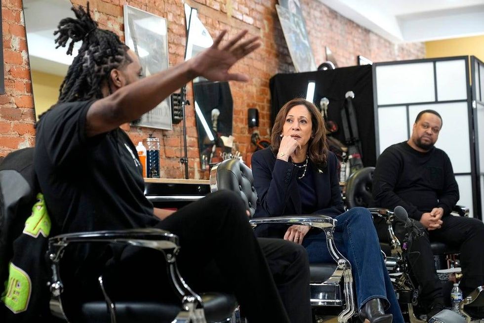 Democratic presidential nominee Vice President Kamala Harris, center, sits in conversation with Black men at Philly Cutz barbershop during a campaign stop, Sunday, Oct. 27, 2024, in Philadelphia.
