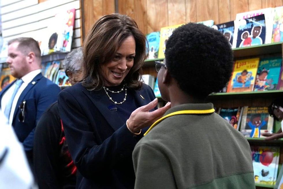 Democratic presidential nominee Vice President Kamala Harris, left, greets a young man at Hakim
