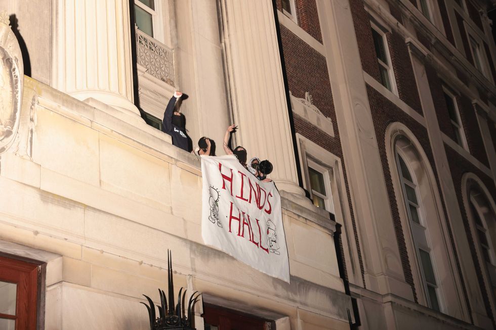Demonstrators from the pro-Palestine encampment show a banner as they barricade themselves inside Hamilton Hall, an academic building at Colombia University, on April 30, 2024 in New York City. Pro-Palestinian demonstrators marched around the "Gaza Solidarity Encampment" at Columbia University as a 2 P.M. deadline to clear the encampment given to students by the university passed.
