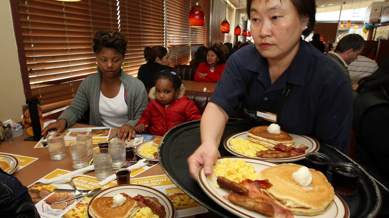 Denny's waitress Fong Van Luben (R) delivers free Grand Slam breakfasts to customers February 3, 2009 in Emeryville, California.