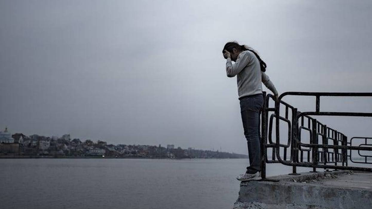 Depressed sad frustrated man stands on the edge of the bridge to jump.