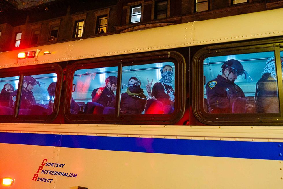 Detained protesters are seen with police officers in an NYPD bus near the Columbia University campus on April 30, 2024